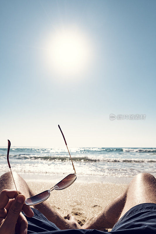 在Pedn Vounder海滩，康沃尔一个田园诗般的阳光明媚的一天，POV男人的腿日光浴。